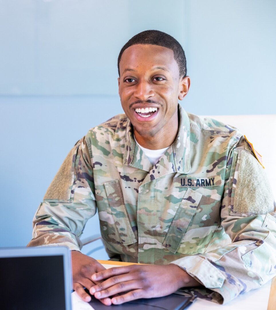 Military officer in camouflage, smiling broadly