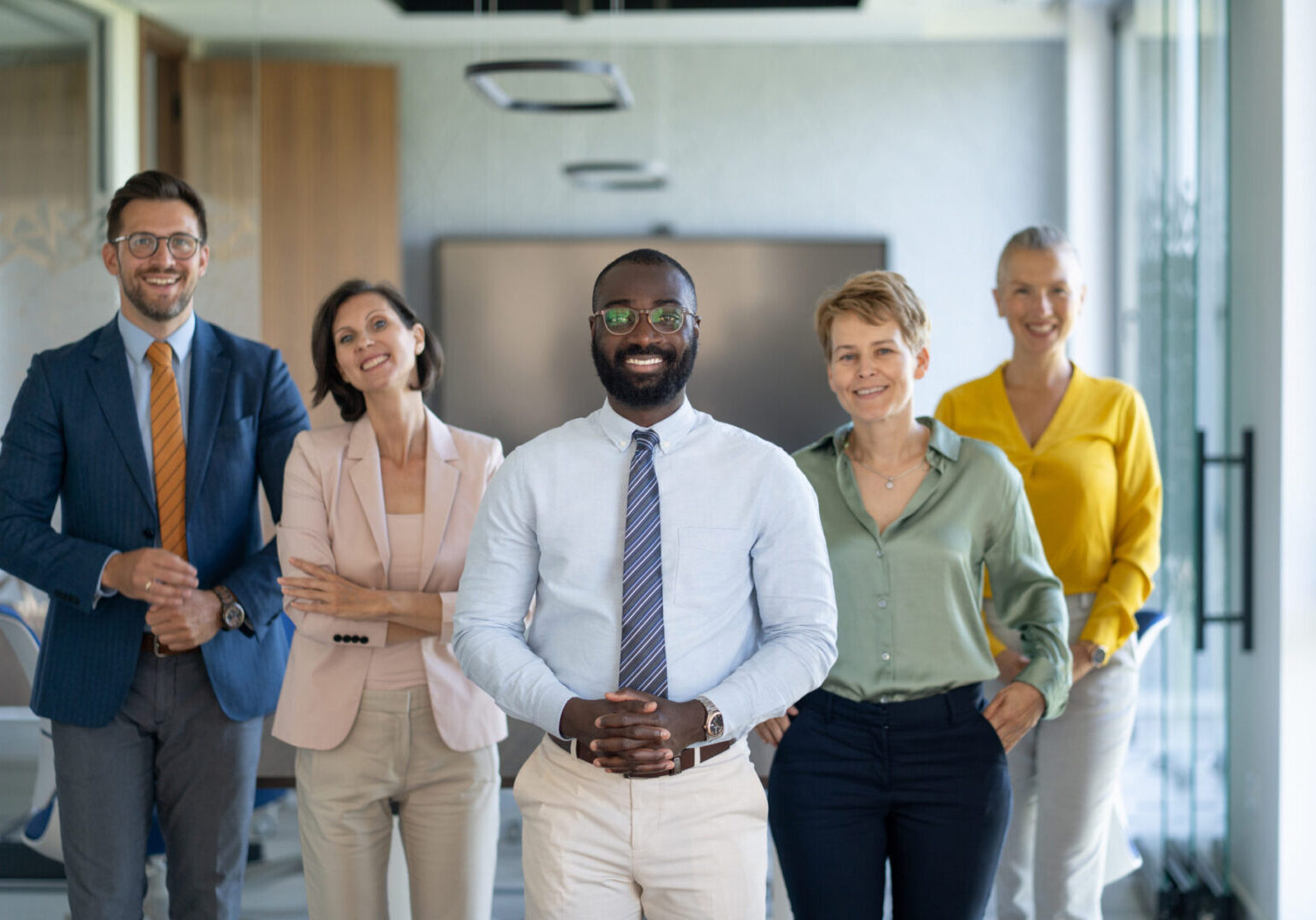 Portrait of a diverse group of business professionals standing together in a modern office, exuding confidence and teamwork